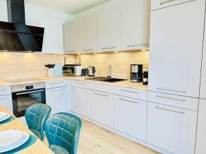 a kitchen with white cabinets and a table and chairs at Küste33-22 Lotta in Tossenserdeich