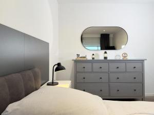 a bedroom with a bed and a dresser with a mirror at Blankwasser 169 in Grömnitzerhagen