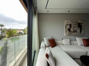 Una sala de estar con un sofá blanco y una ventana. en The Address to Ocean - By AppartAli, en Anfa-Supérieur