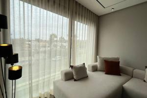 Una habitación con un sofá frente a una ventana grande. en The Address to Ocean - By AppartAli, en Anfa-Supérieur