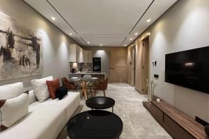 Una sala de estar con un sofá blanco y un televisor. en The Address to Ocean - By AppartAli, en Anfa-Supérieur