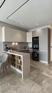 Una cocina con gabinetes blancos y un horno de estufa. en The Address to Ocean - By AppartAli, en Anfa-Supérieur 14 fotos más