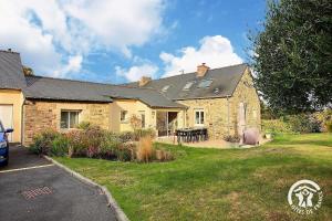 a brick house with a table in a yard at La croix au roi in Landéhen