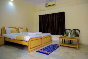 een slaapkamer met een bed, een tafel en een raam bij The Lala Hotel and Resort in Pushkar