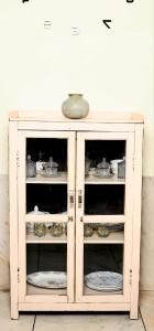 une armoire blanche avec des assiettes et de la vaisselle dans l'établissement Heritage Stay in Johari Bazaar, à Jaipur