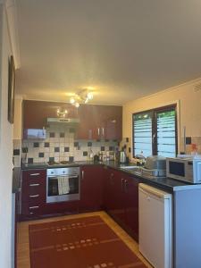 cocina con armarios marrones y horno con fogones en SHANTY Timber Chalet, en Criccieth