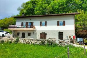 a large white house with a stone wall at Gemma del Lagorai in Torcegno