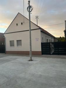 a pole in front of a building with a fence at Prenociste-apartmani Laki S in Kula +1 photo
