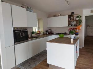 a kitchen with white cabinets and a stove top oven at Gemma del Lagorai in Torcegno