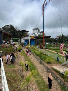 een groep mensen die rond een tuin staan bij Bee tree adventure park tent stay in Madikeri