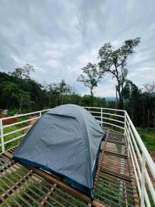een tent bovenop een houten terras bij Bee tree adventure park tent stay in Madikeri