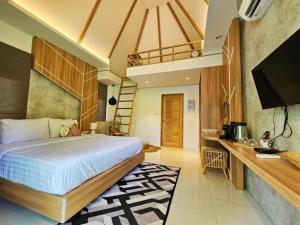 a bedroom with a bed and a desk and a television at Siri Lagoona Resort in Nong Prue