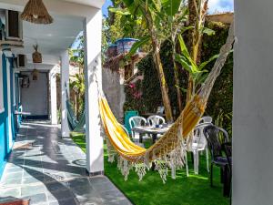a patio with a hammock and a table and chairs at Recanto D'Ajuda in Arraial d'Ajuda