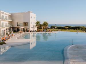 a large swimming pool next to a building at Grupotel Conil Playa in Cádiz