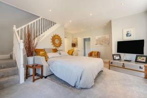 a bedroom with a bed and a flat screen tv at Old Lakenham by Group Retreats in Boughton Monchelsea