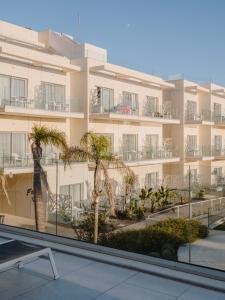 a building with palm trees in front of it at Grupotel Conil Playa in Cádiz