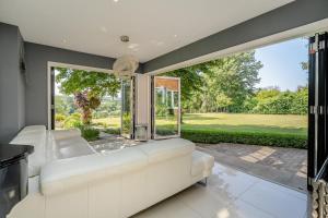 a living room with a white couch and a large window at Old Lakenham by Group Retreats in Boughton Monchelsea +38 photos