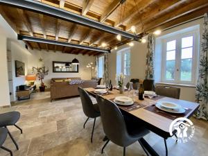 a large dining room with a table and chairs at Le mas de l'ecluse in Caux-et-Sauzens