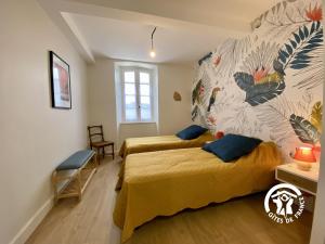 a bedroom with two beds and a mural on the wall at Le mas de l'ecluse in Caux-et-Sauzens +54 photos