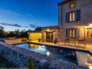 a swimming pool in front of a house at Le mas de l'ecluse in Caux-et-Sauzens