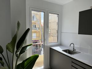 una cocina con fregadero y ventana en The Place Tenerife, en Santa Cruz de Tenerife