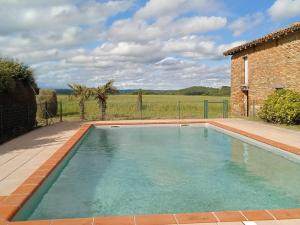 a swimming pool in front of a house at Le pigeonnier de Pauly in Mirabel