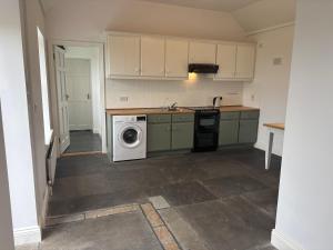 a kitchen with a washing machine and a sink at Little Reds Seaview Cottage in Liscannor