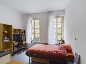 a bedroom with a bed and two windows at Résidence Kley Marseille République in Marseille