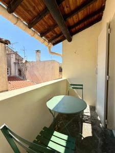 una mesa y una silla en un balcón en Appartement Cosy avec balcon, en Arles 8 fotos más