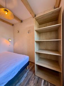 Un dormitorio con una cama y una estantería. en Appartement Cosy avec balcon, en Arles