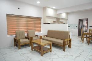 a living room with chairs and a table and a counter at Oceanus Retreat in Kottiyam