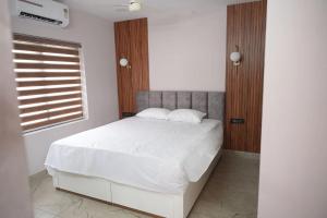 a bedroom with a bed with white sheets and a window at Oceanus Retreat in Kottiyam +12 photos