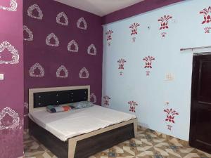 a bedroom with a bed in a purple wall at Hotel O The Brothers Inn in Bāra Banki