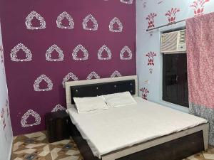 a bedroom with a bed with a purple wall at Hotel O The Brothers Inn in Bāra Banki