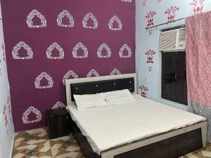 a bedroom with a bed with a purple wall at Hotel O The Brothers Inn in Bāra Banki