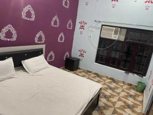 a bedroom with a bed and a window with a fan at Hotel O The Brothers Inn in Bāra Banki