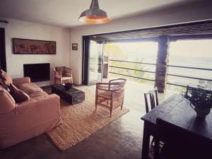 a living room with a couch and a table at Die Ou Kliphuis in Plettenberg Bay