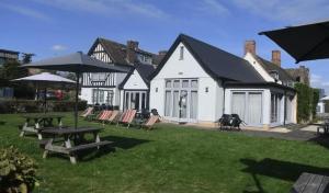 a house with a picnic table and chairs in the yard at The Red Lion Hotel in Cambridge +1 photo