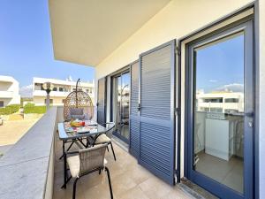 a patio with a table and chairs on a balcony at Pêra Secret Garden 2 With Pool by Homing in Pêra