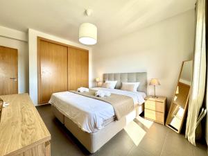 a bedroom with a large bed with white sheets at Pêra Secret Garden 2 With Pool by Homing in Pêra +30 photos