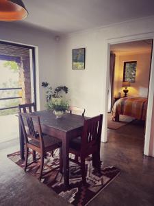 a dining room with a table and chairs and a bedroom at Die Ou Kliphuis in Plettenberg Bay