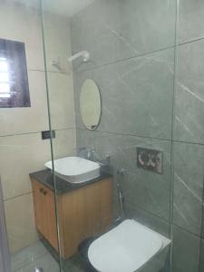 a bathroom with a sink and a toilet and a mirror at Oceanus Retreat in Kottiyam