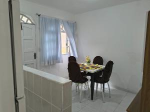 a dining room with a table and four chairs at Estadia Férias e Trabalho in Vila Velha