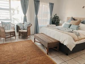 Un dormitorio con una cama y sillas y una ventana. en Cozy one bed, just a short walk to the beach, en Strand