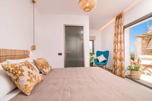 a bedroom with a large bed and a blue chair at Villa Halakas by Villa Plus in Katastárion +11 photos
