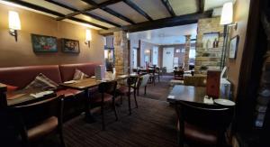 a restaurant with tables and chairs and a bar at The Red Lion Hotel in Cambridge