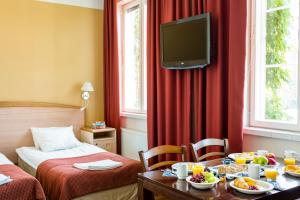 a hotel room with a table with food and a tv at Hotelli Ville in Tampere