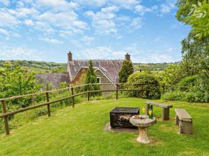 un jardín con una mesa y una parrilla frente a una casa en 9 Bed in Hay-on-Wye 73069, en Painscastle