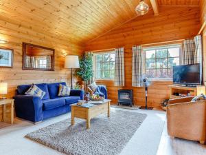 a living room with a blue couch and a tv at 2 Bed in Blandford Forum 61027 in Child Okeford