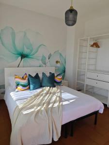 a bedroom with a large white bed with colorful pillows at Villa Greta Hotel Rooms & Suites in Taormina
